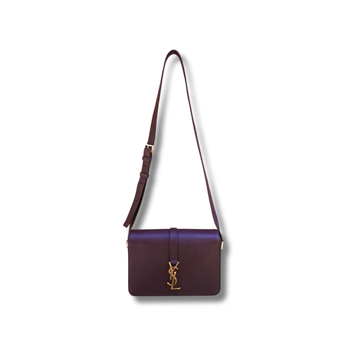 A burgundy Saint Laurent satchel crossbody bag with a gold-finish logo, displayed against a white background