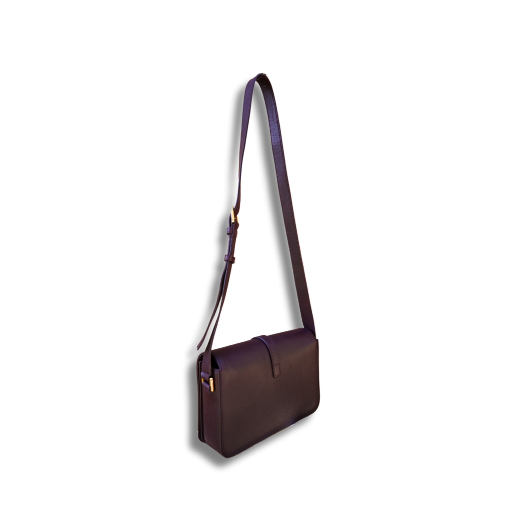 A burgundy Saint Laurent satchel crossbody bag with a gold-finish logo, displayed against a white background