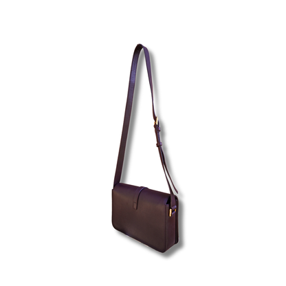 A burgundy Saint Laurent satchel crossbody bag with a gold-finish logo, displayed against a white background