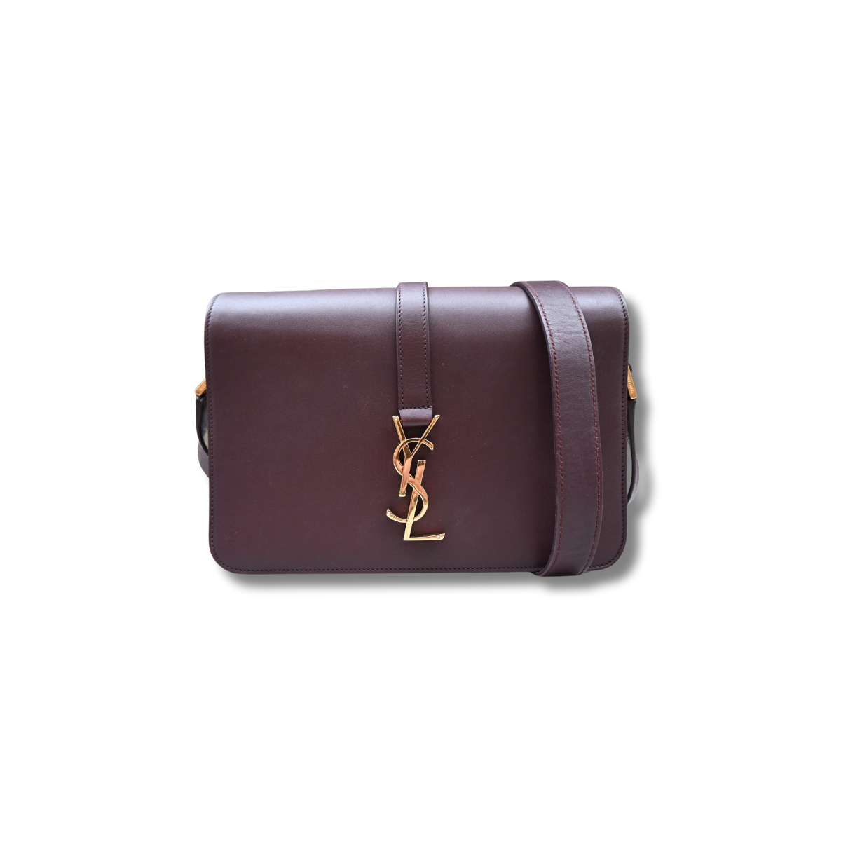 A burgundy Saint Laurent satchel crossbody bag with a gold-finish logo, displayed against a white background