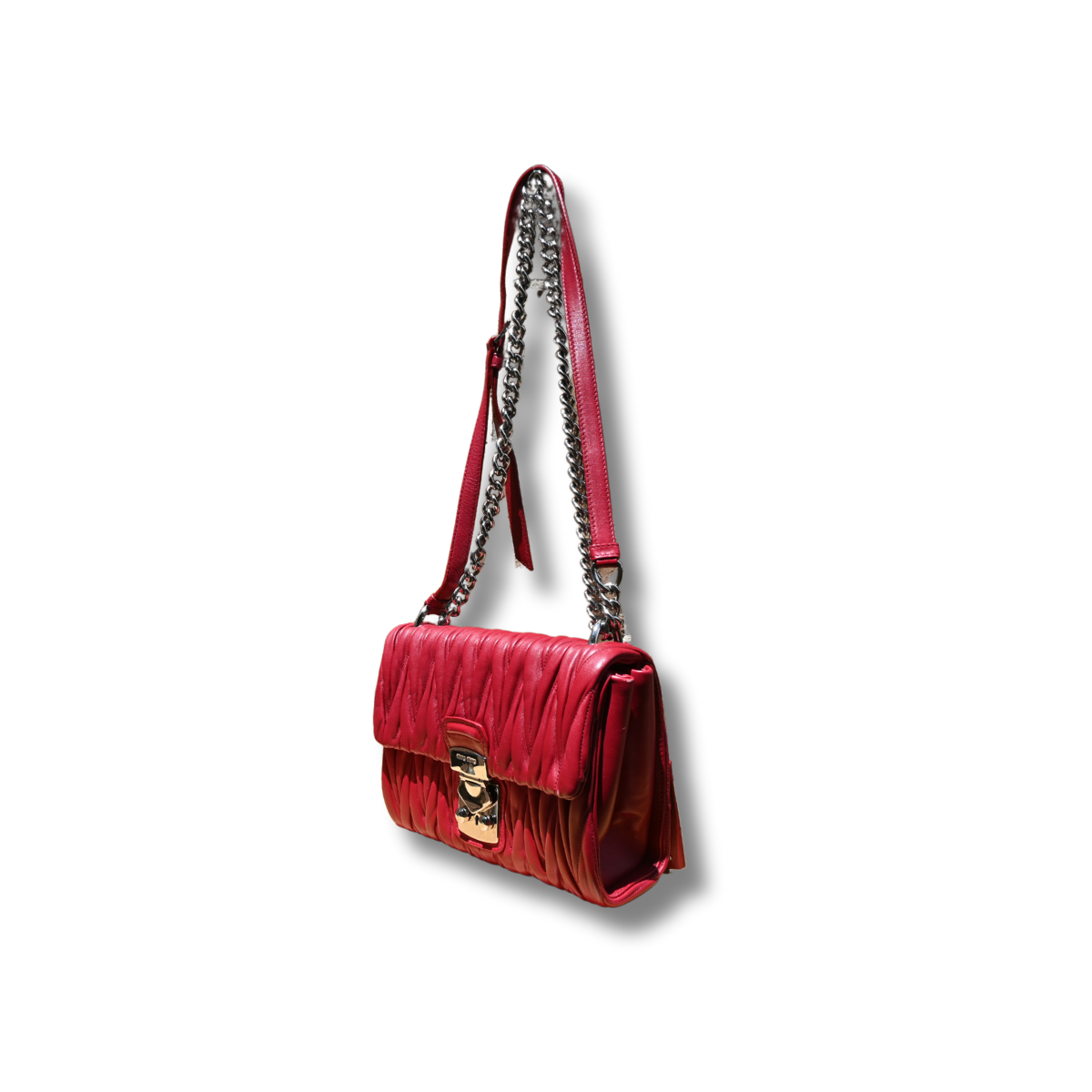 A red Miu Miu matelassé nappa leather shoulder bag with a textured finish, featuring a logo on the front and a chain strap.